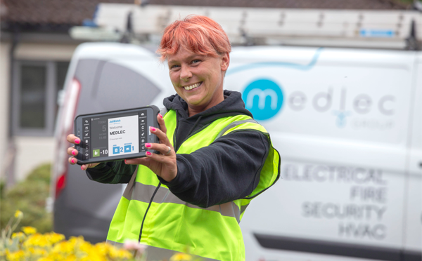 MEDLEC employee hoding a BigChange mobile device